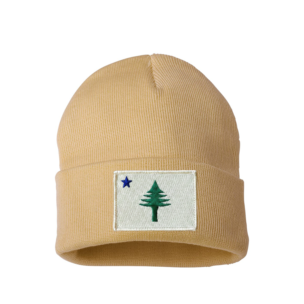 Beige beanie with a patch featuring a star and a tree from the 1901 Maine state flag on a white background